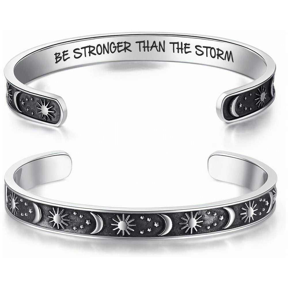 The Solstice Cuff, a silver open cuff engraved with suns, moons, and stars
